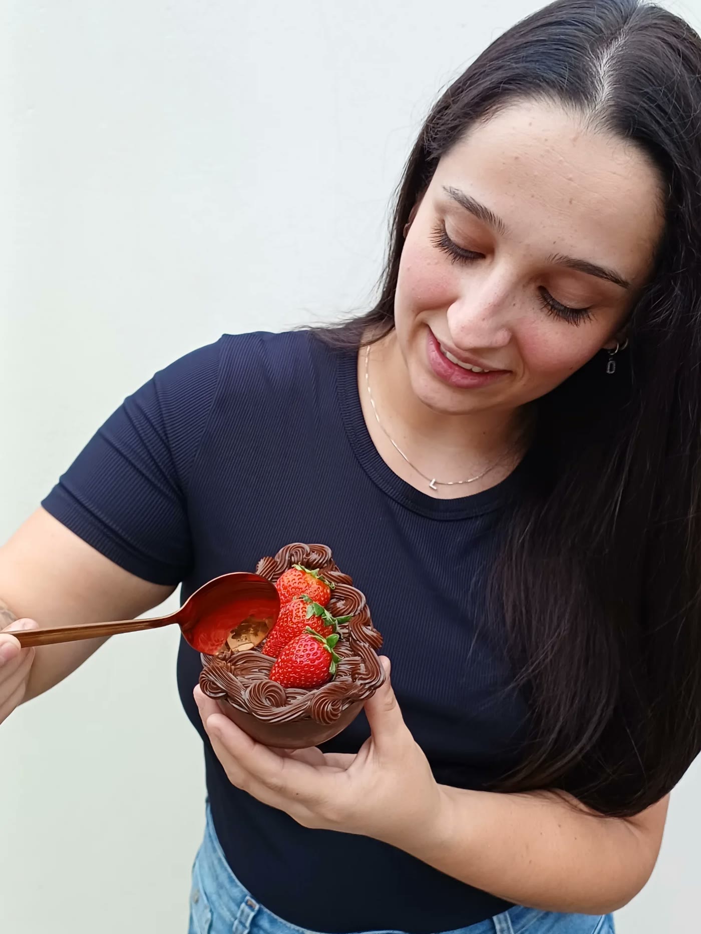 Confeiteira da Doce Terapia segurando um morango do amor